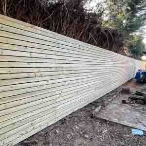 Newly installed slatted fencing viewed along the line, showing straight and even boards.