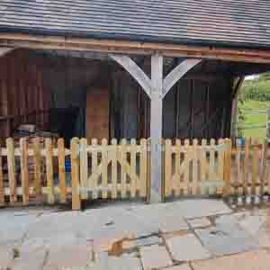 Decorative picket fence and gate around a timber porch at a residential property.