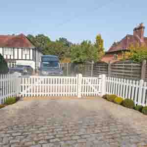 White picket fencing with matching gate enclosing a front garden entrance.