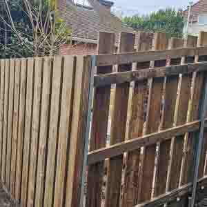Tall picket gate and return panel forming a smart entrance beside a house.