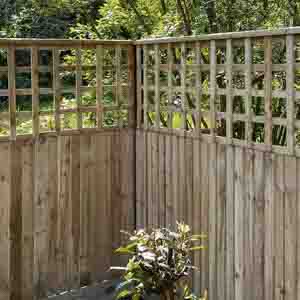 Corner run of closeboard fencing finished with square-lattice trellis panels above.