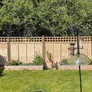 Angled garden boundary with convex trellis sections stepping down along the slope.