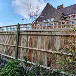 Angled corner fence with diamond-lattice trellis and feature post caps.