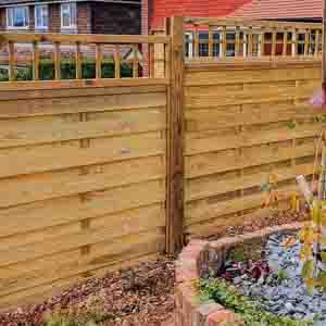 Closeboard panels with integrated trellis along a paved garden path.