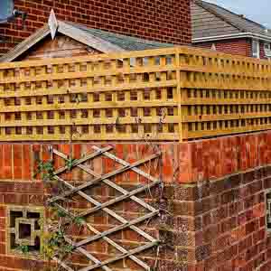 Corner post detail with trellis-topped fencing running to a patio area.