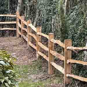Traditional timber post and rail fence enclosing a countryside garden area.