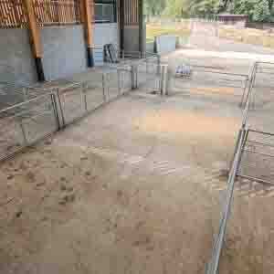 Concrete yard with sturdy timber fencing for livestock and machinery areas.