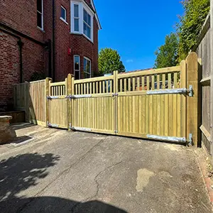 Timber curved-top driveway gates with open slatted upper section and galvanised fittings, installed by Green Leaves Fencing & Gates in East Grinstead.