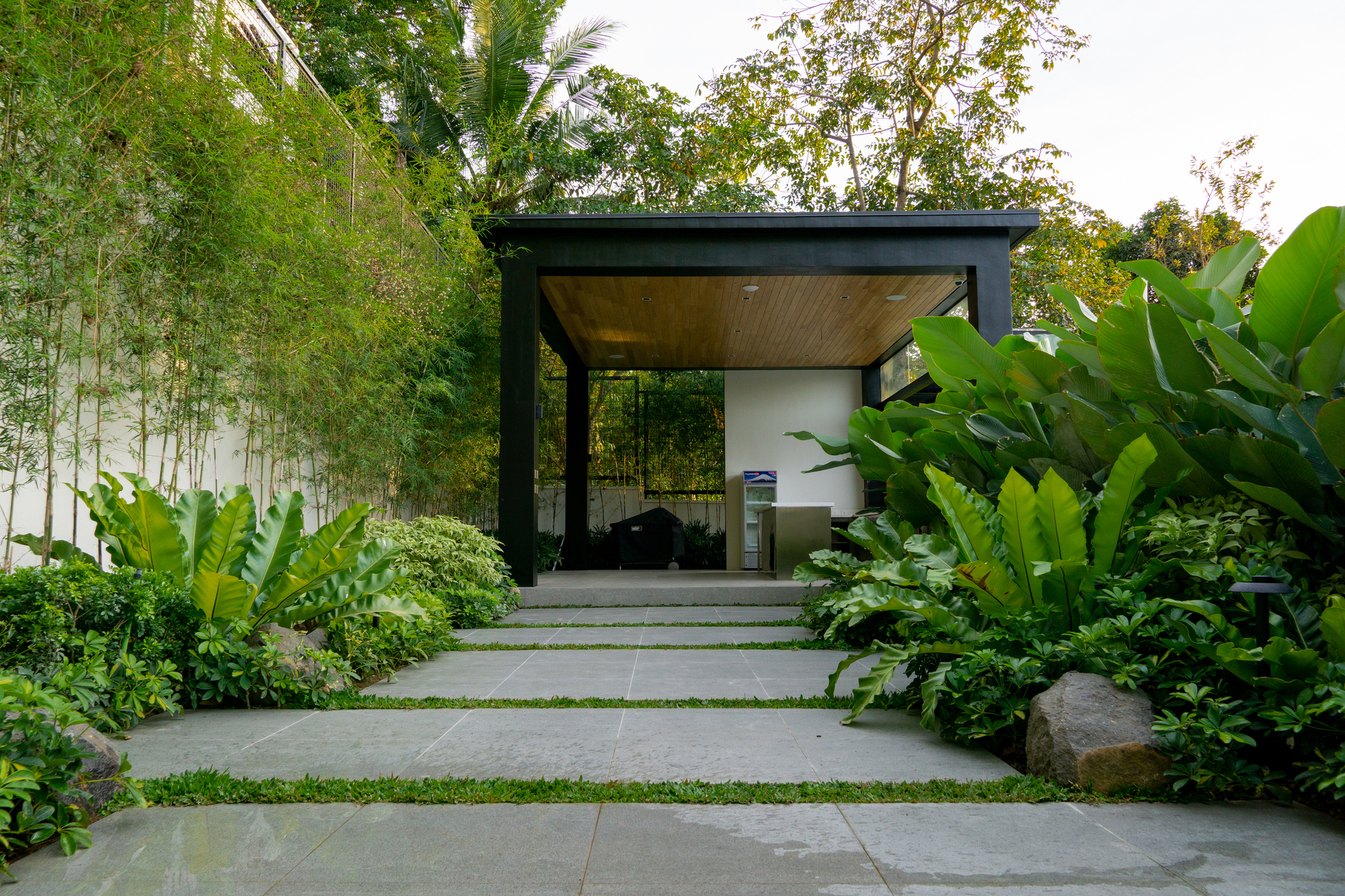 The Perch — Boulders and different hues of green lead up to the outdoor kitchen area where guests and homeowners can cook with a view.