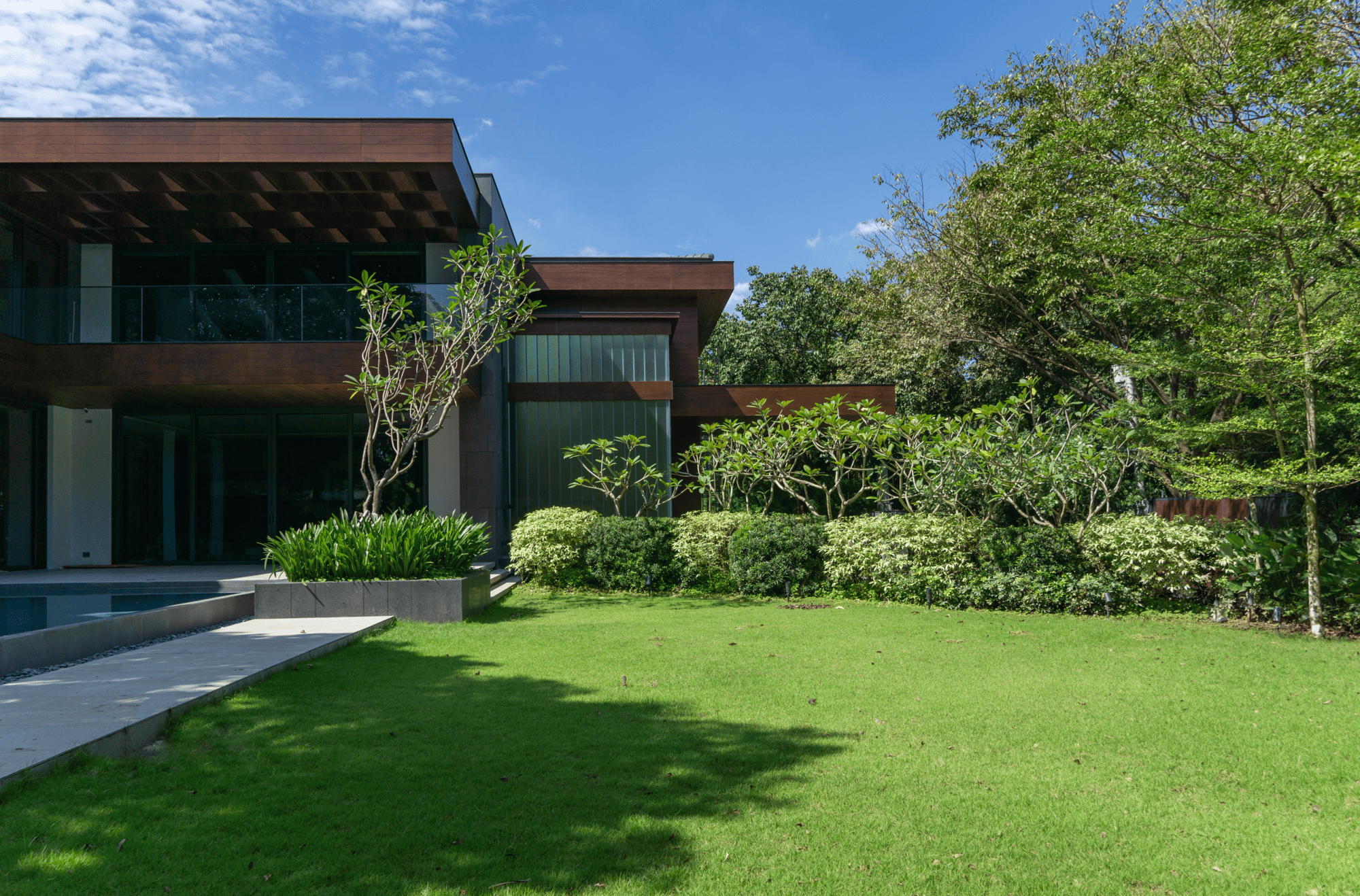 Private Forest — Curated planting surround the well-manicured lawn to balance out the structured landscape elements of the property.