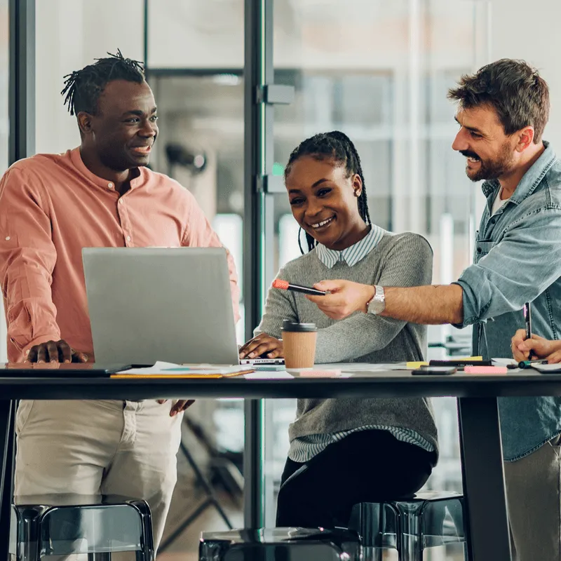 Team collaborating on Edu-Jobs learning modules with laptop and notes.