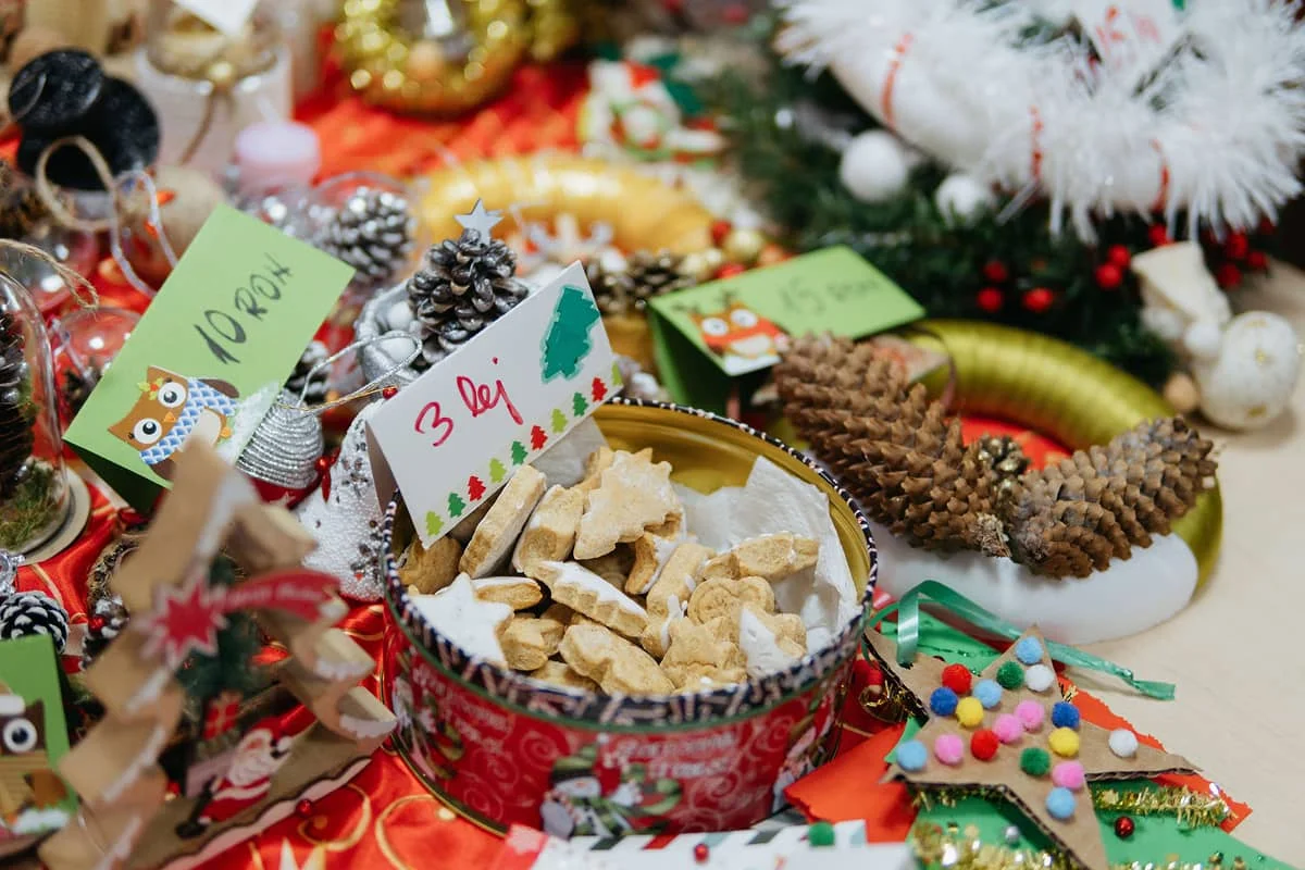 Az adventi vásár egyik asztalán láthatók a gyerekek által készített termékek: karácsonyi díszek és mézeskalács.