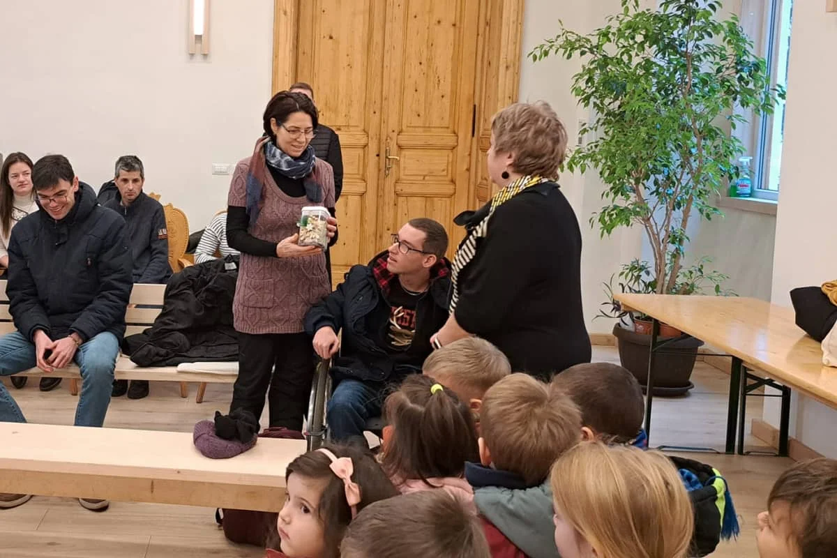 Az óvoda közössége átadja a jótékonysági vásáron összegyűlt adományt, a gyerekek jelenlétében.