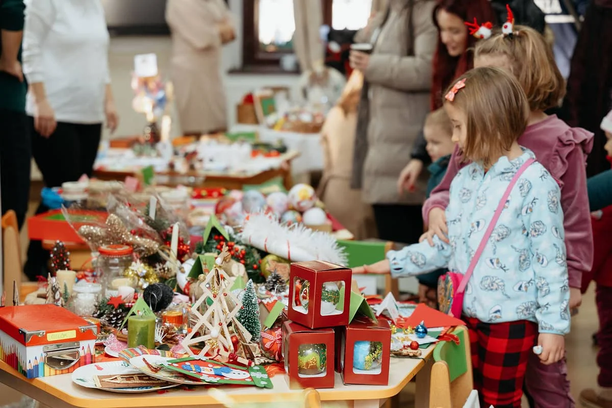 Gyerekek válogatnak a karácsonyi kézműves portékák között az óvoda adventi vásárán.