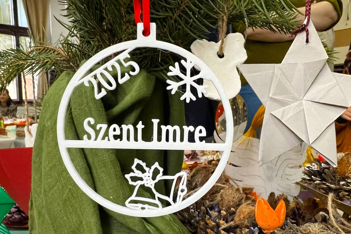 Decorațiune de Crăciun cu inscripția 2025 Szent Imre, agățată pe o ramură de brad, printre alte decorațiuni realizate manual