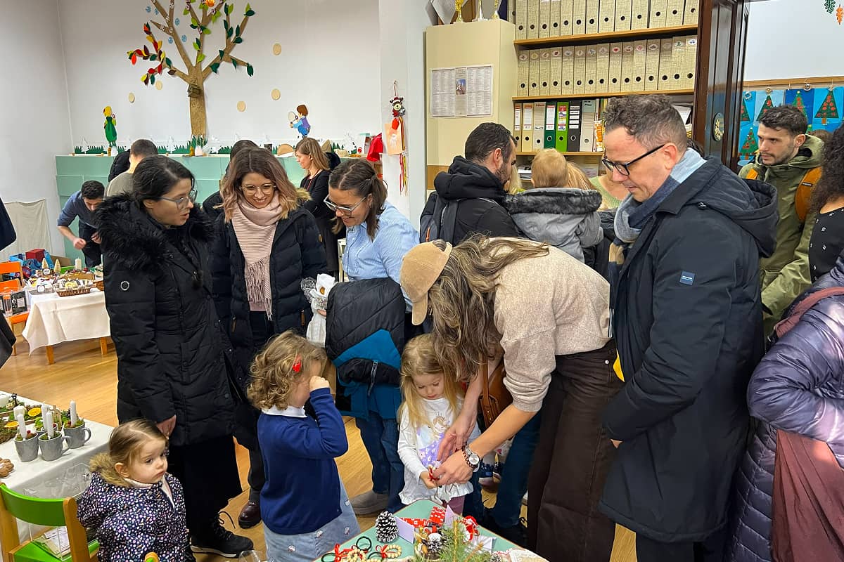 Atmosferă familială la Târgul de Advent al grădiniței, părinții și copiii aleg dintre decorațiunile realizate manual