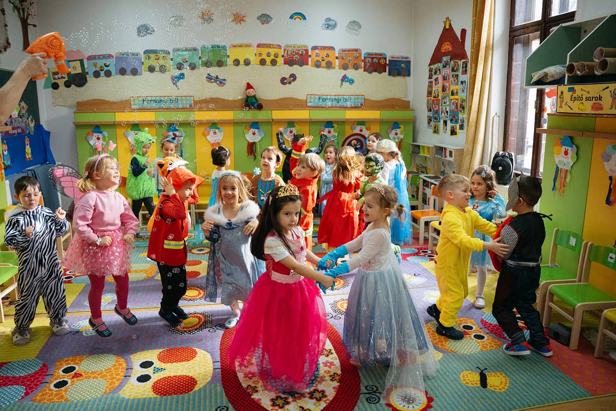 Színes jelmezekben táncoló óvodások.