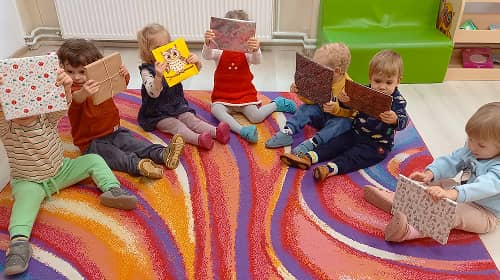 Bölcsődés gyermekek becsomagolt könyvekkel a Nemzetközi Könyvajándékozás Napján.