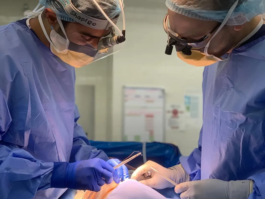 Surgeons performing a facial cosmetic procedure in a sterile operating room