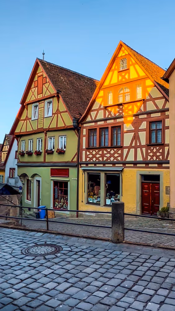 Bunte Fachwerkhäuser in einer gepflasterten Gasse die speziellen Versicherungsbedarf hat