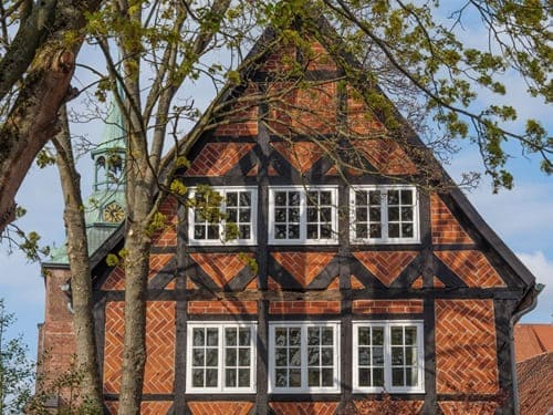 Backsteinfachwerk mit gemauerten Gefachen und dunklem Holztragwerk. Ziegel in Fischgrät- oder Kreuzverband sorgen für Stabilität und prägen das charakteristische Erscheinungsbild dieser Bauweise.