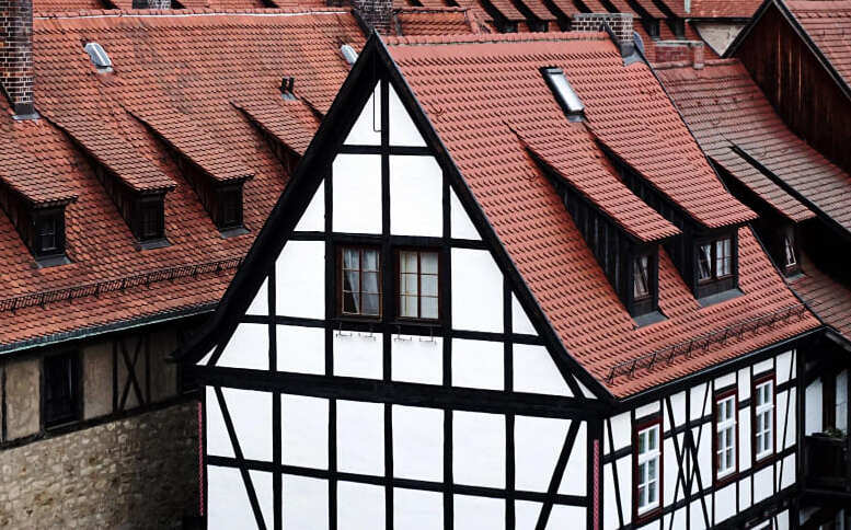 Dicht stehende Fachwerkhäuser einer Altstadt mit roten Ziegeldächern und Gauben