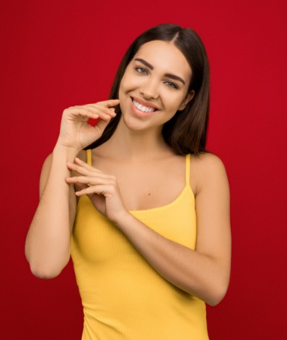 Vrouw in gele t-shirt voor een rode achtergrond