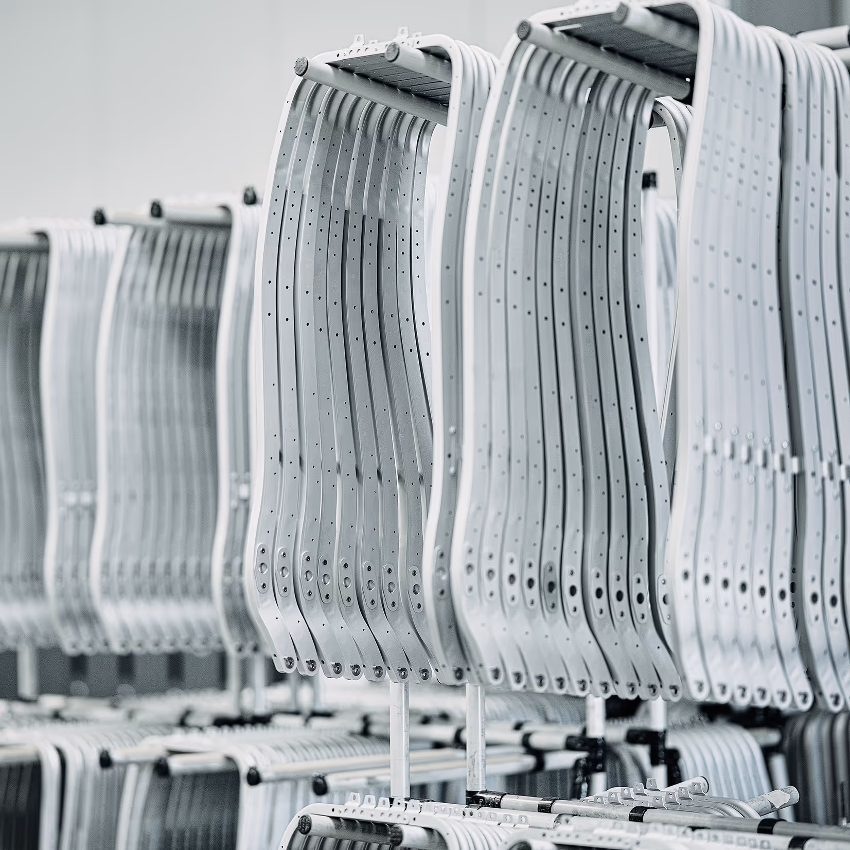 Racks of precision-engineered aluminium seating parts by HEGGEMANN in serial production — lightweight structures for certified aerospace interiors and cabin assemblies.