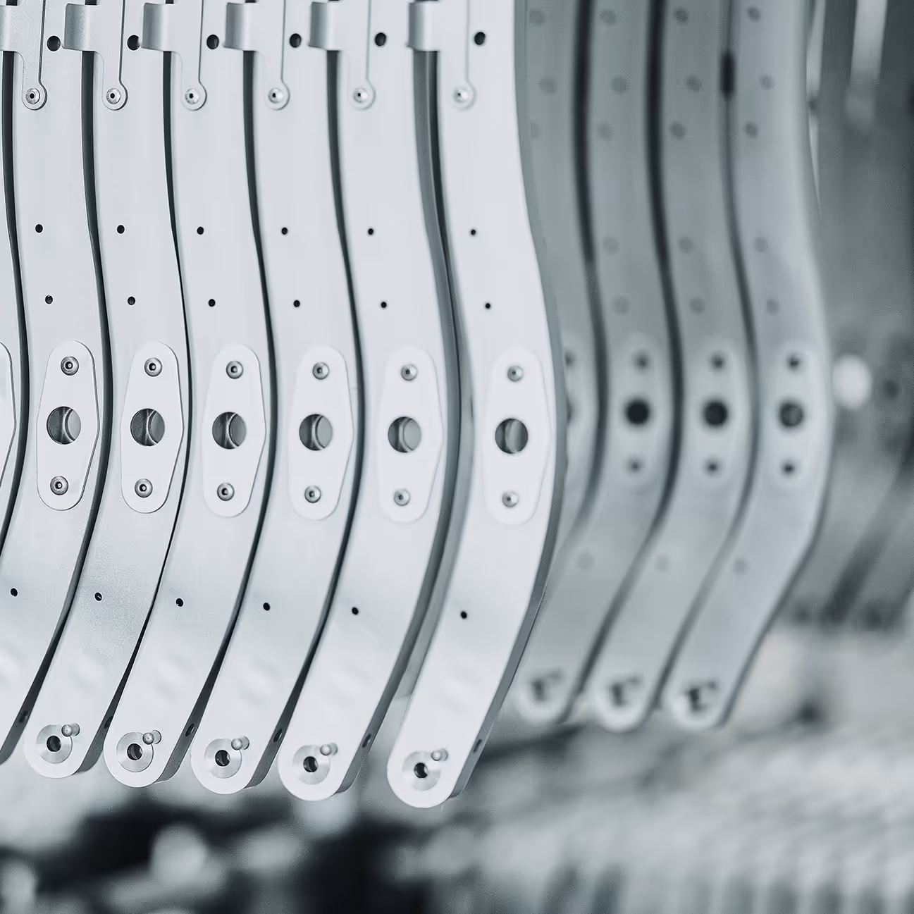 Series of precision-engineered aluminium seating parts by HEGGEMANN in serial production, aligned for assembly — lightweight structural components for certified aerospace interiors.