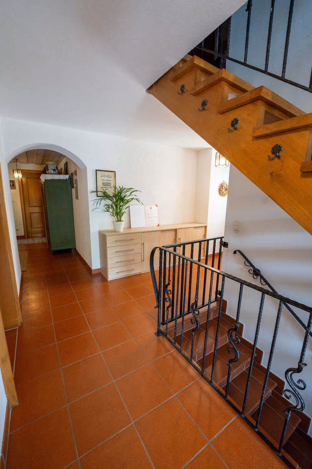 Zeltsperger Eingangsbereich mit Treppe, Flur und einer kleinen Kommode.