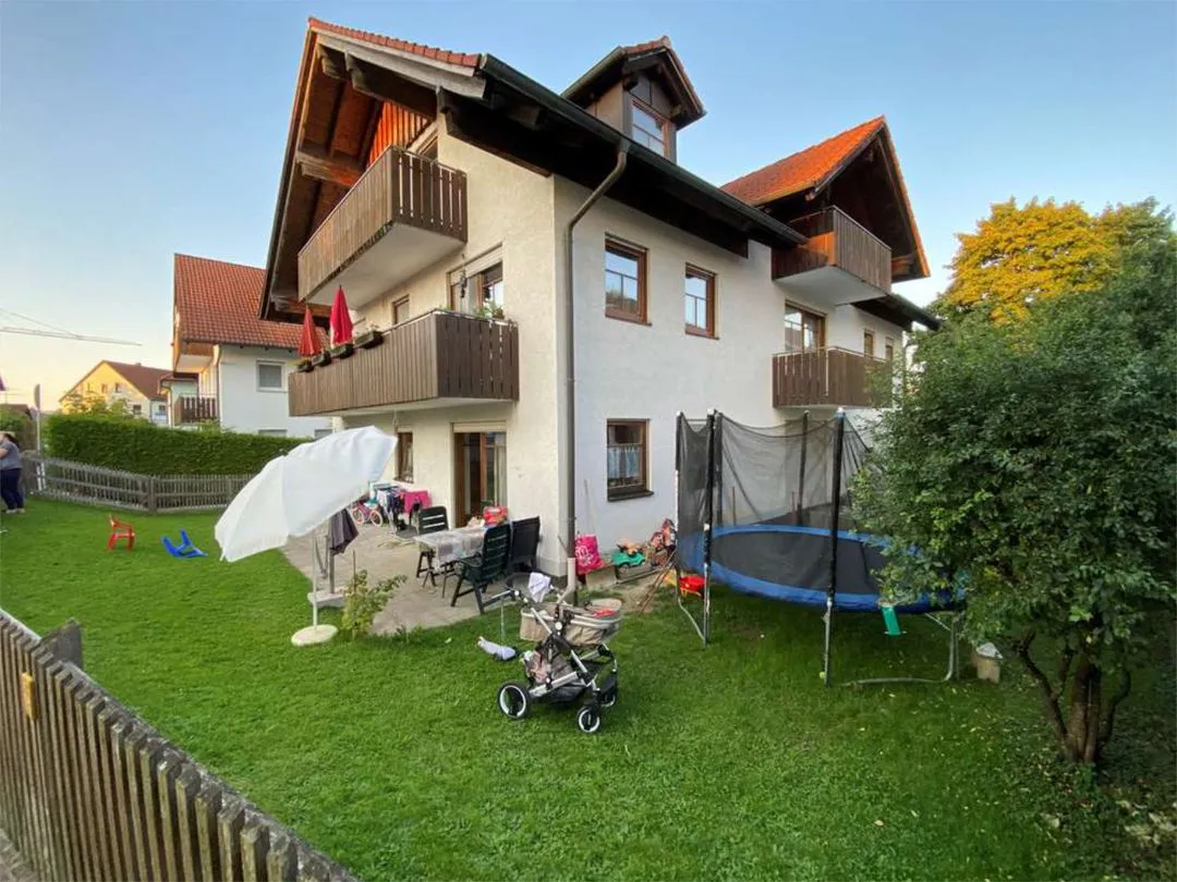 Gepflegtes Mehrfamilienhaus mit Balkonen, Garten und Spielbereich.