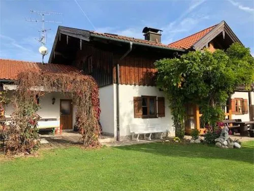 Charmantes Landhaus mit Holzdetails, überdachter Terrasse und Garten.