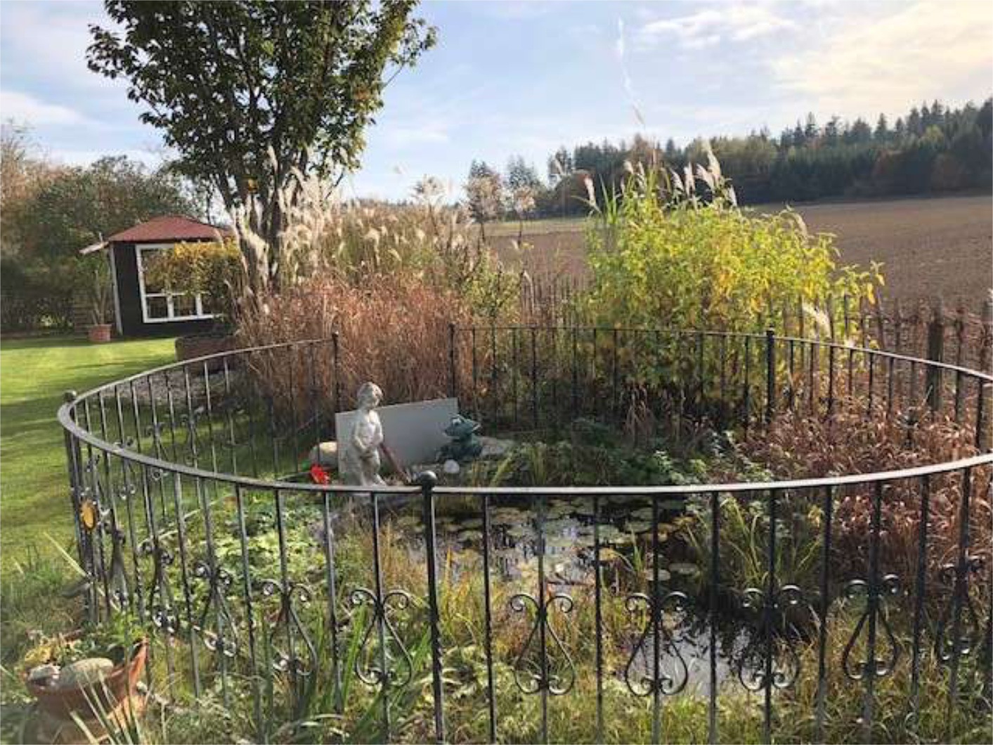 Garten mit kleinem Brunnen und Ausblick ins Grüne, Zeltsperger Immobilien.