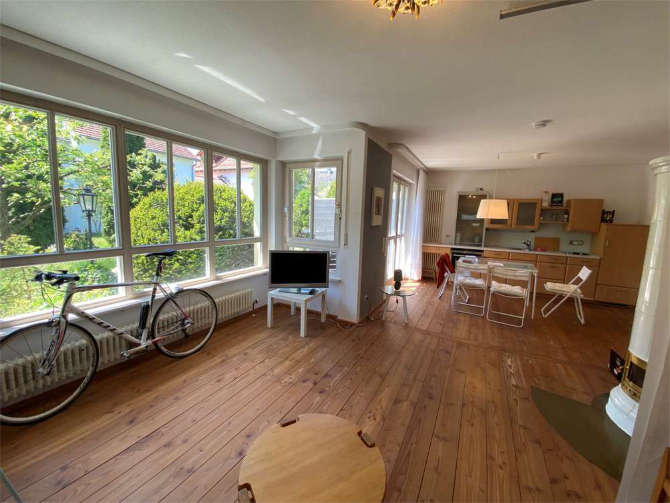 Helles Wohnzimmer mit großen Fenstern und Holzboden, Zeltsperger Immobilien Referenz.