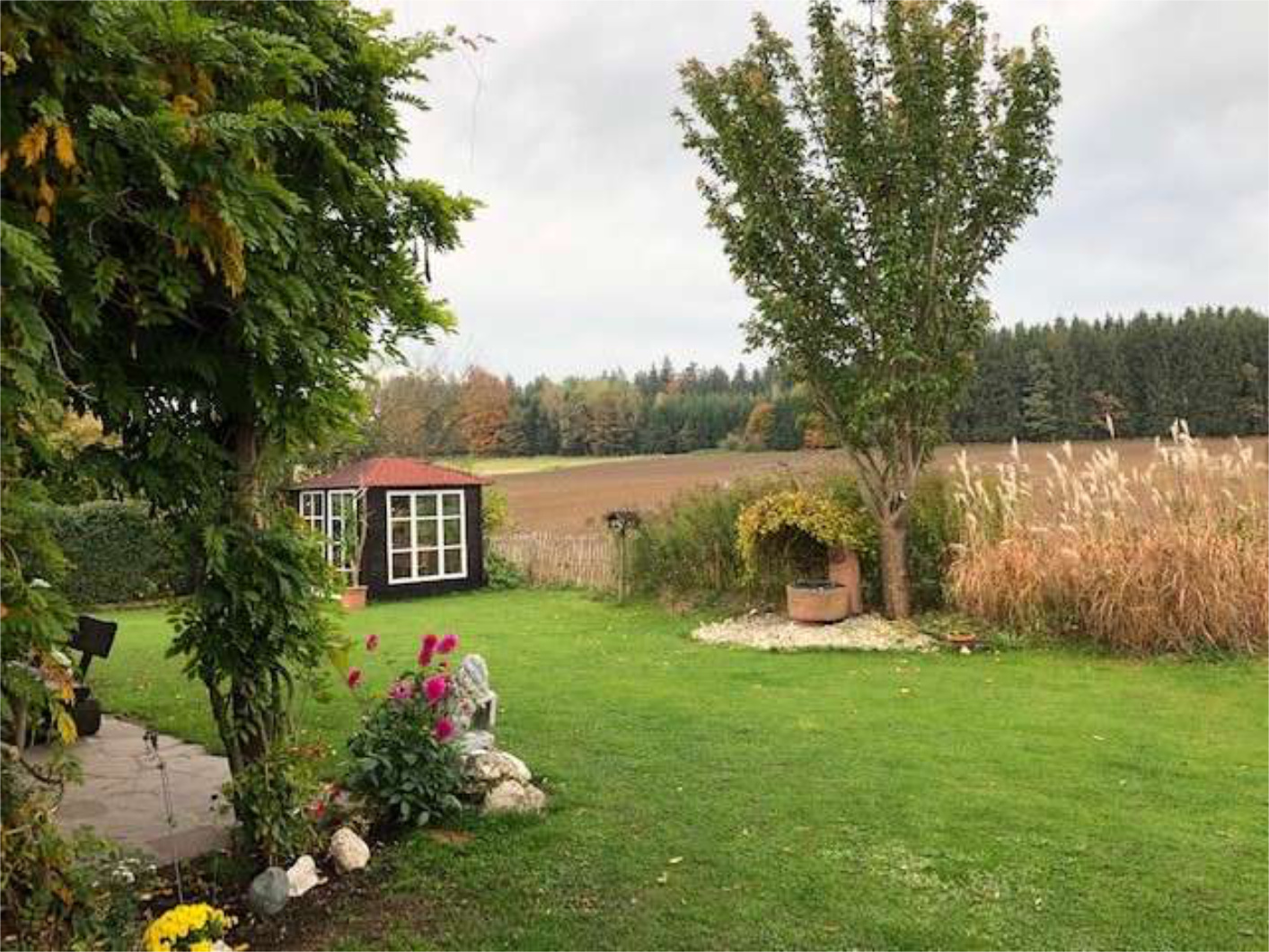Gepflegter Garten mit Bäumen und Sträuchern, Wohnimmobilie von Zeltsperger.