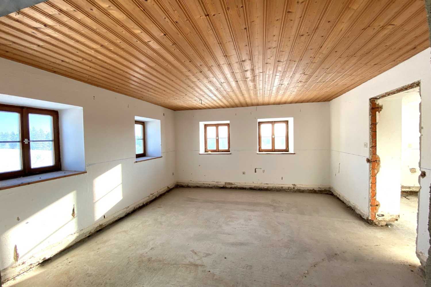 Helles Zimmer mit Holzdecke im Bestandsgebäude, Zeltsperger Immobilien Objekt.