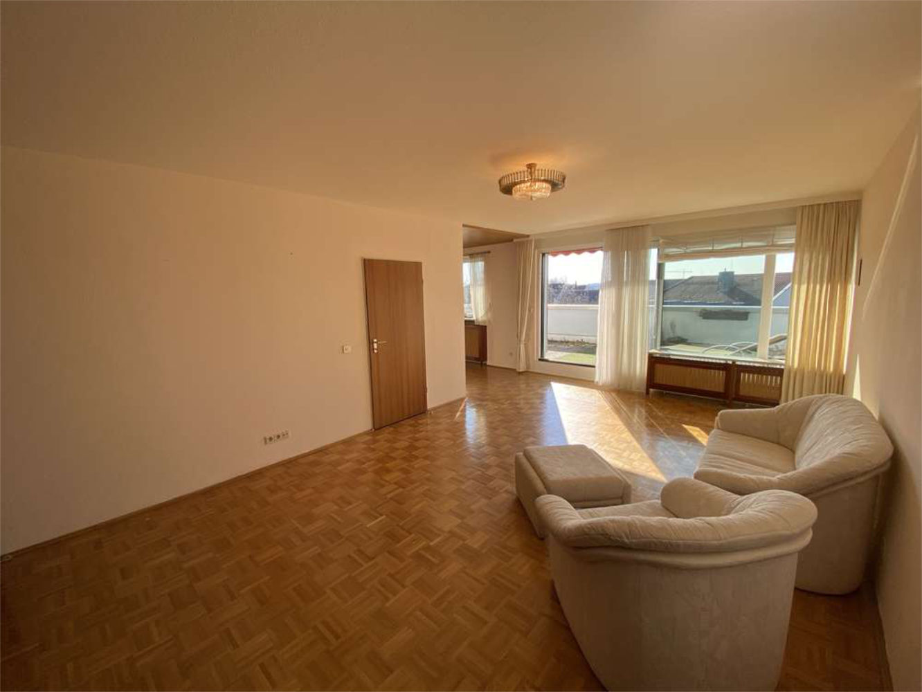 Großes Wohnzimmer mit Parkettboden und Panoramafenster, Zeltsperger Immobilien Referenzobjekt.