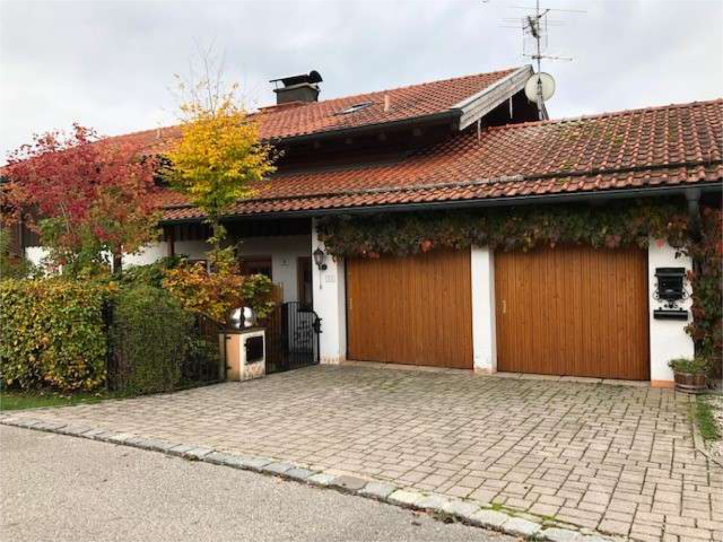 Doppelgarage mit rotem Ziegeldach und gepflasterter Einfahrt, Zeltsperger Immobilien.