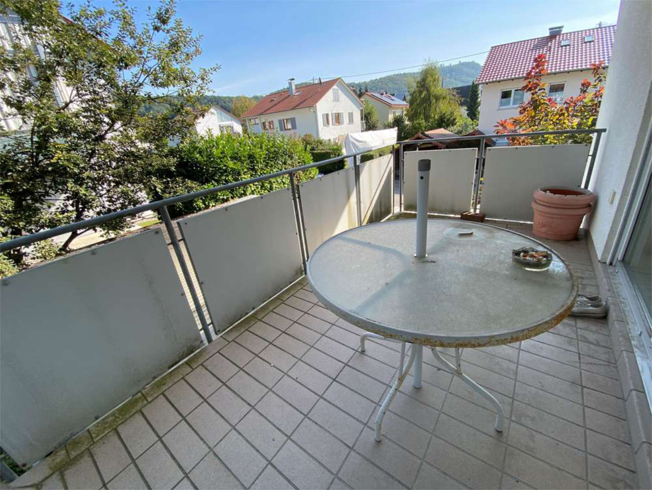 Großer Balkon mit Tisch und Blick auf Wohnsiedlung, Zeltsperger Immobilien.