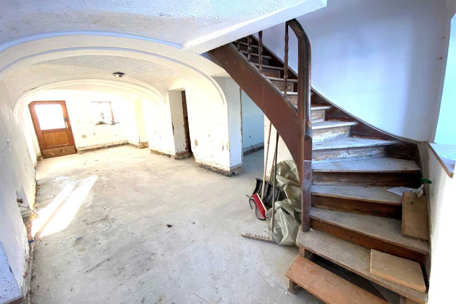 Altbau-Treppenhaus mit Rundbogen-Eingang und Naturlicht, Zeltsperger Immobilien.