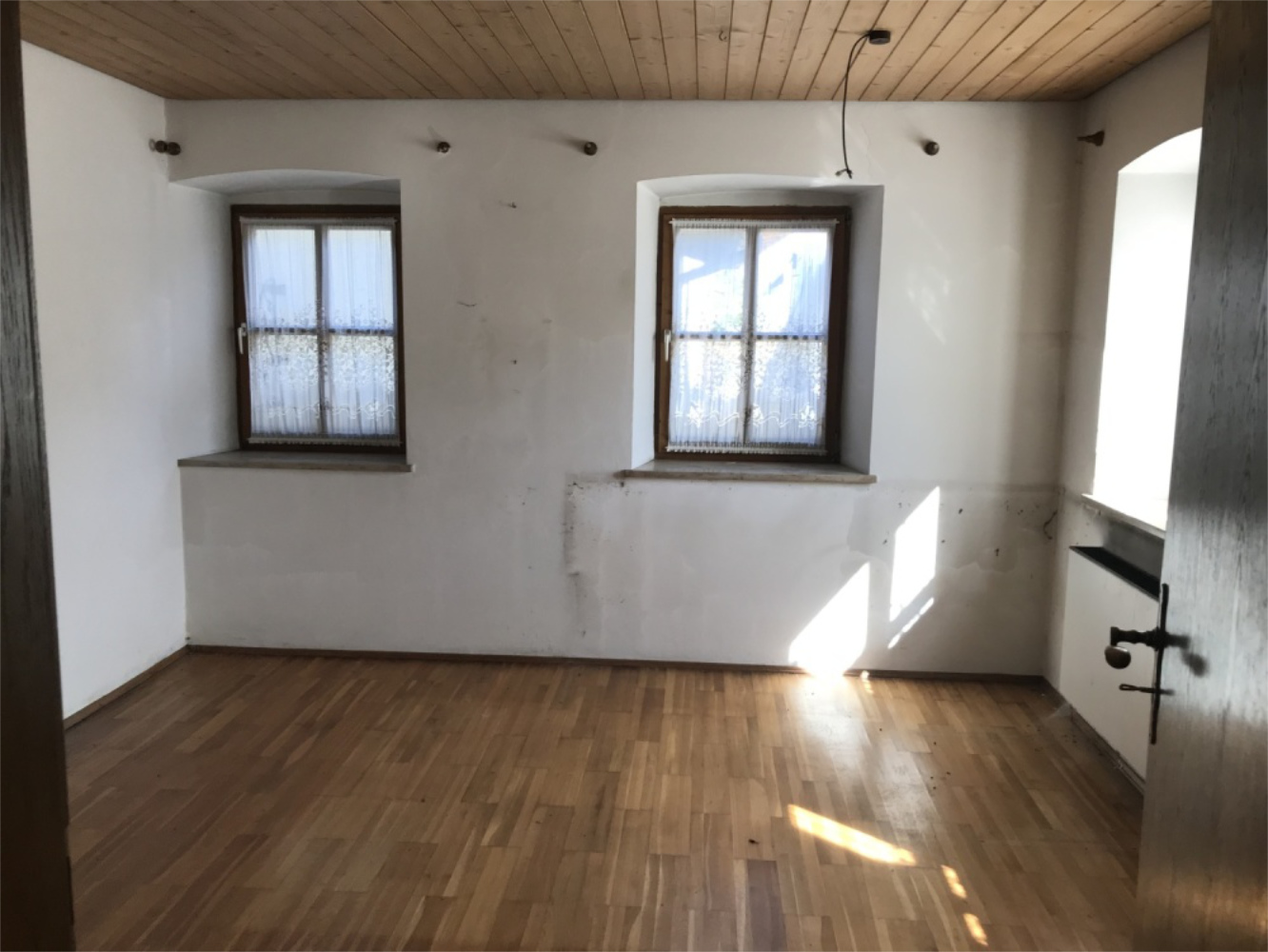 Helles Zimmer in einem Altbau mit Holzboden und Holzdecke, Referenz Zeltsperger Immobilien.