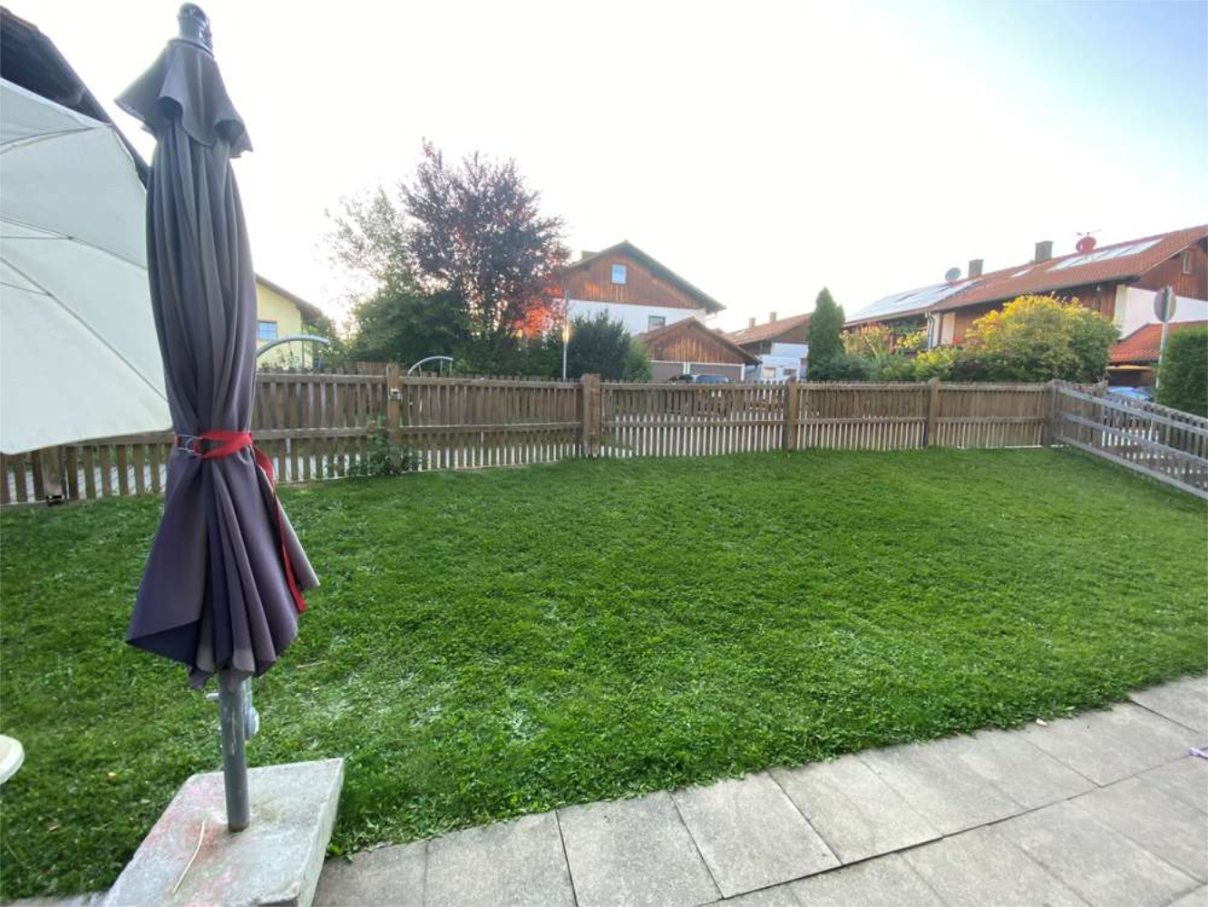 Gepflegter Garten mit Terrasse und Sonnenschirm in Wohnsiedlung, Zeltsperger Immobilien.