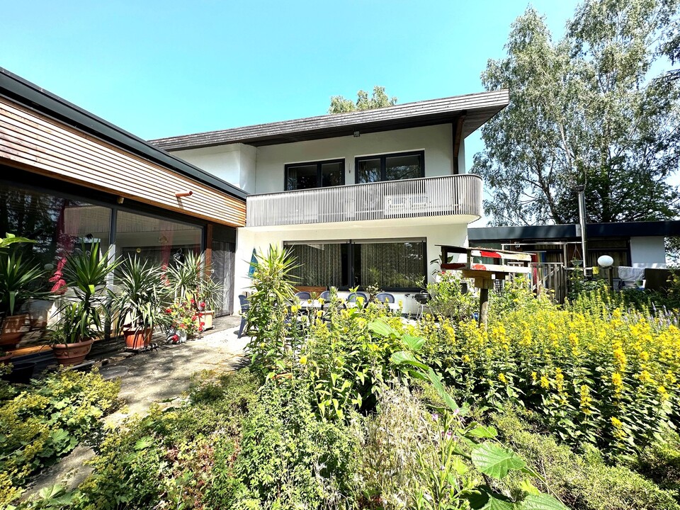 Außenansicht mit Balkon und Garten – vielseitiges Wohnhaus mit Büro- und Praxismöglichkeit