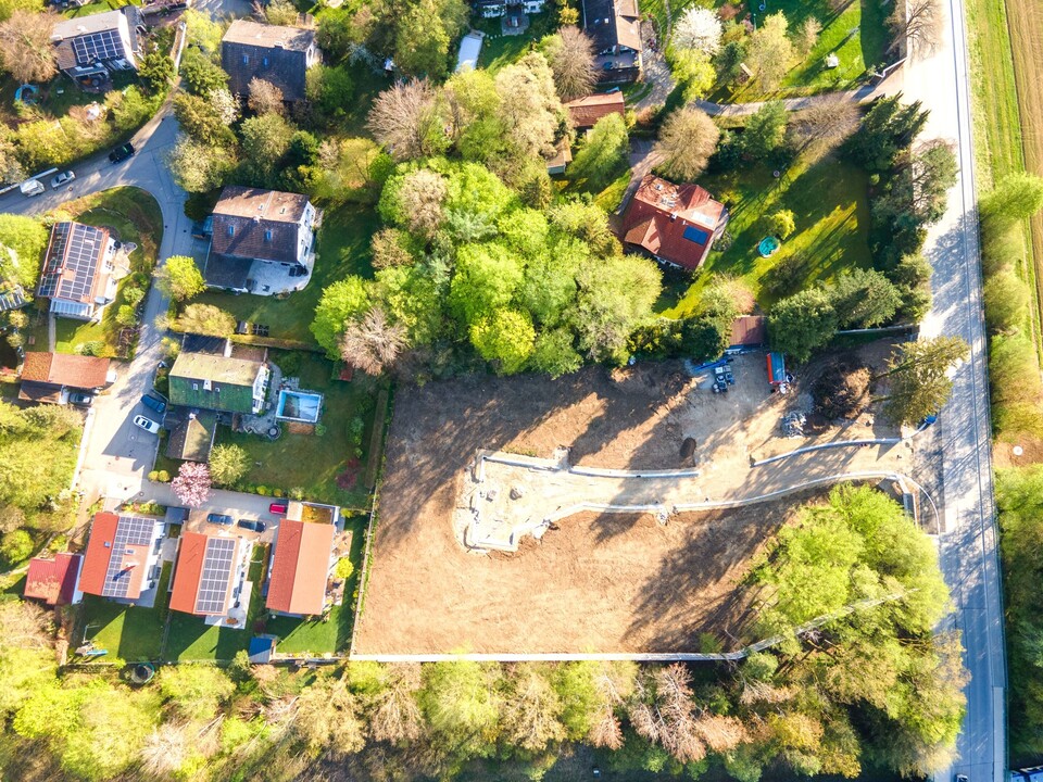 Drohnenaufnahme mit Häusern und Bauland – idyllische Ortsrandlage mit Waldnähe in Deisenhofen