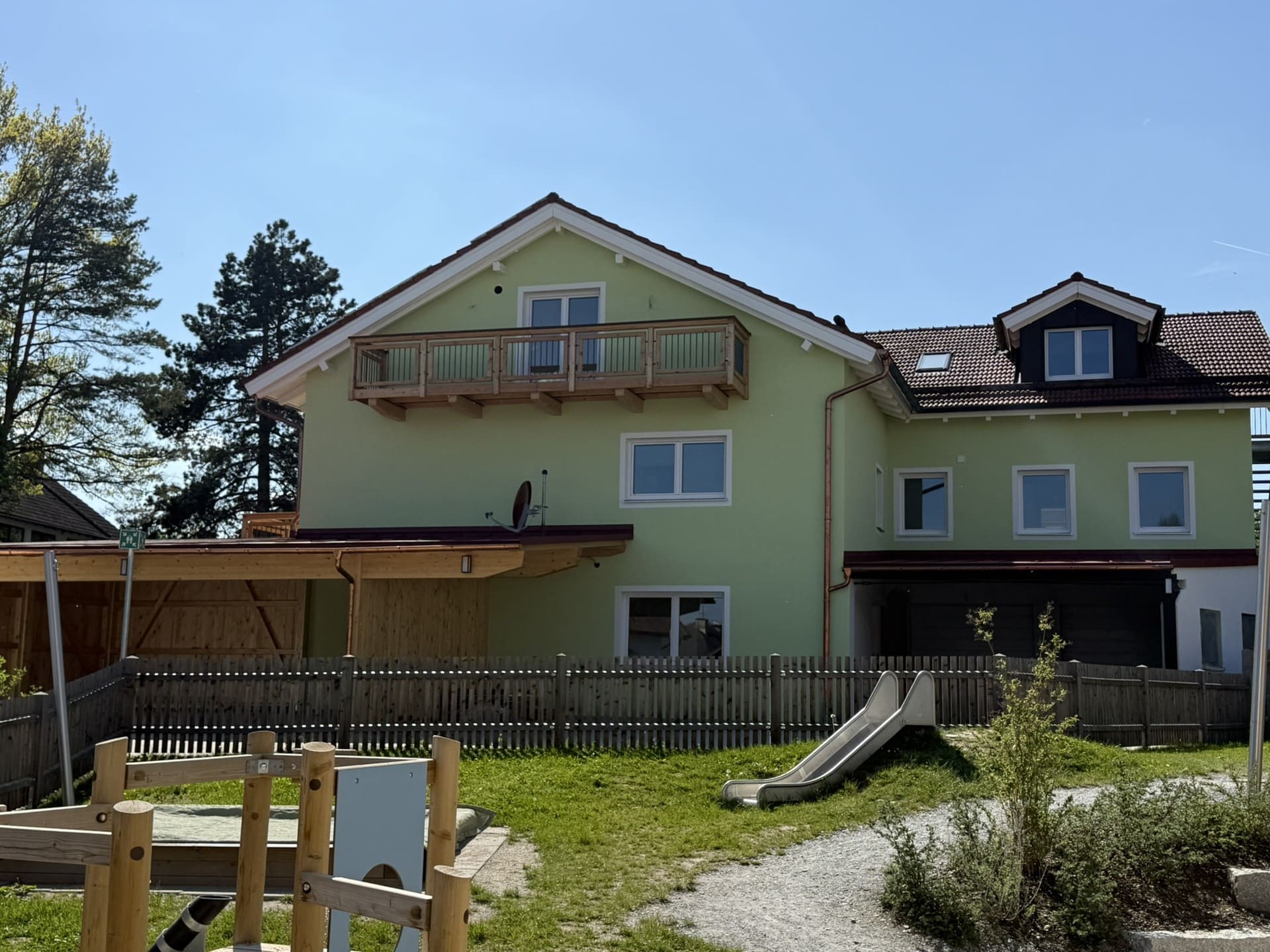 Außenansicht des Mehrfamilienhauses mit Gartenbereich – moderne Wohnung in Seenähe