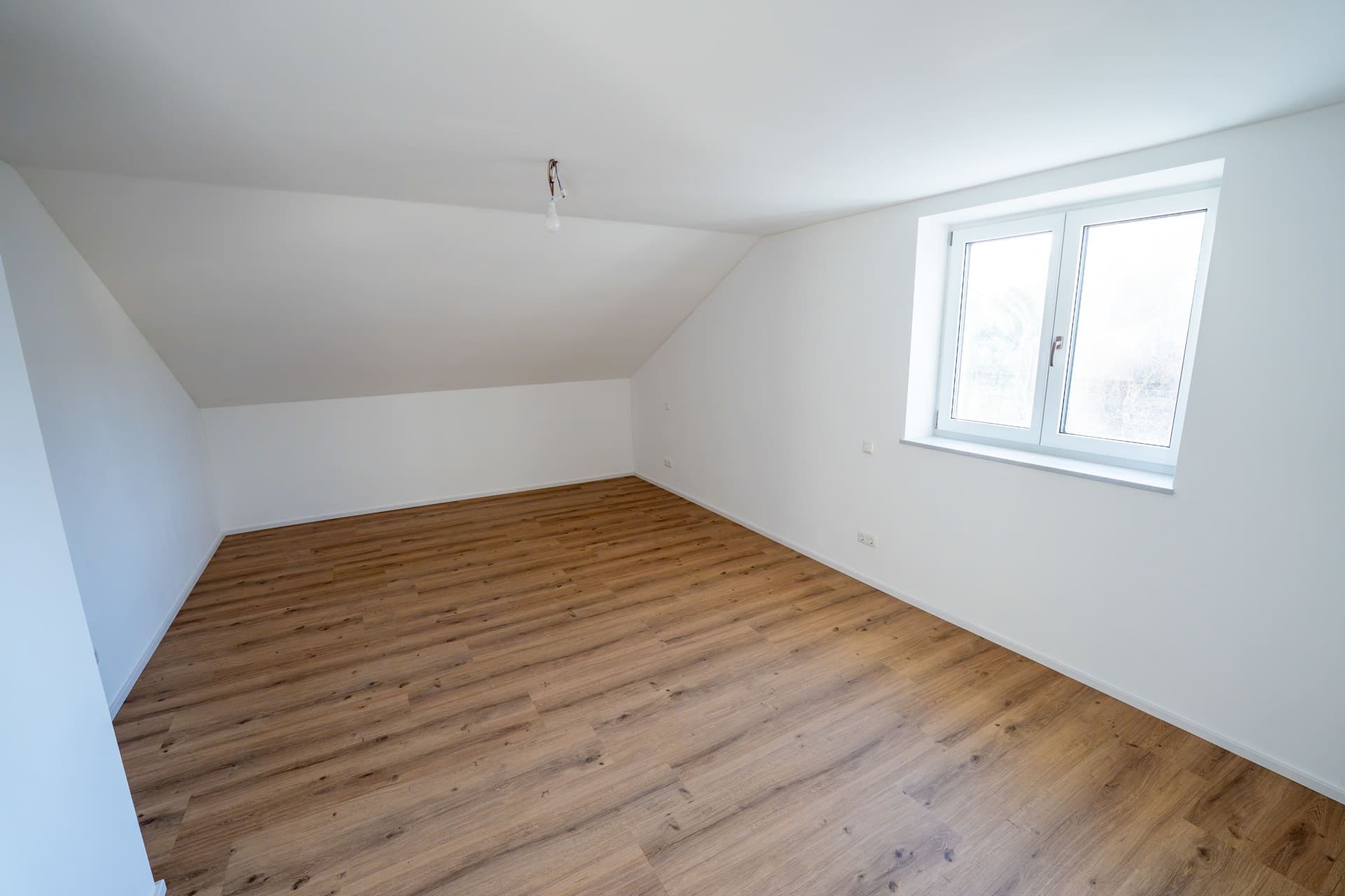 Helles Schlafzimmer mit Dachfenster – gemütliches Apartment mit Vinylboden und Fußbodenheizung