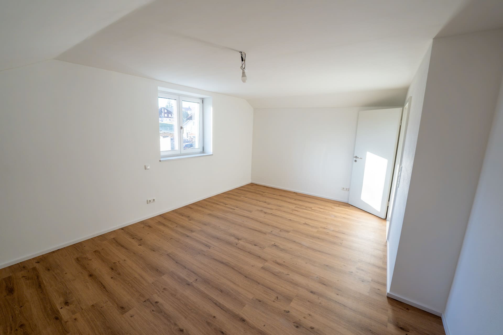 Helles Wohnzimmer mit Holzoptikboden – großzügiger Wohnbereich in der Neubauwohnung