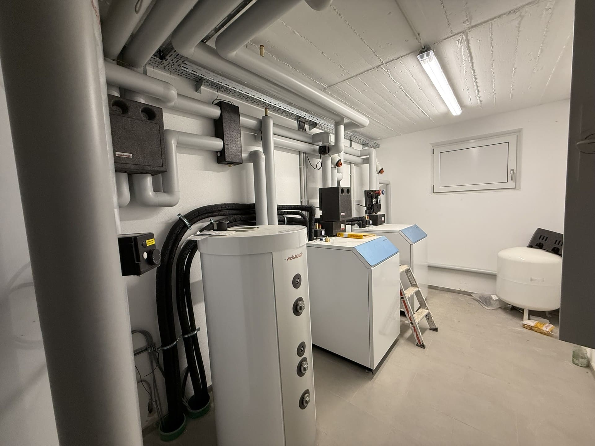 Heizungsraum mit moderner Technik – energieeffiziente Luftwärmepumpe im sanierten Gebäude