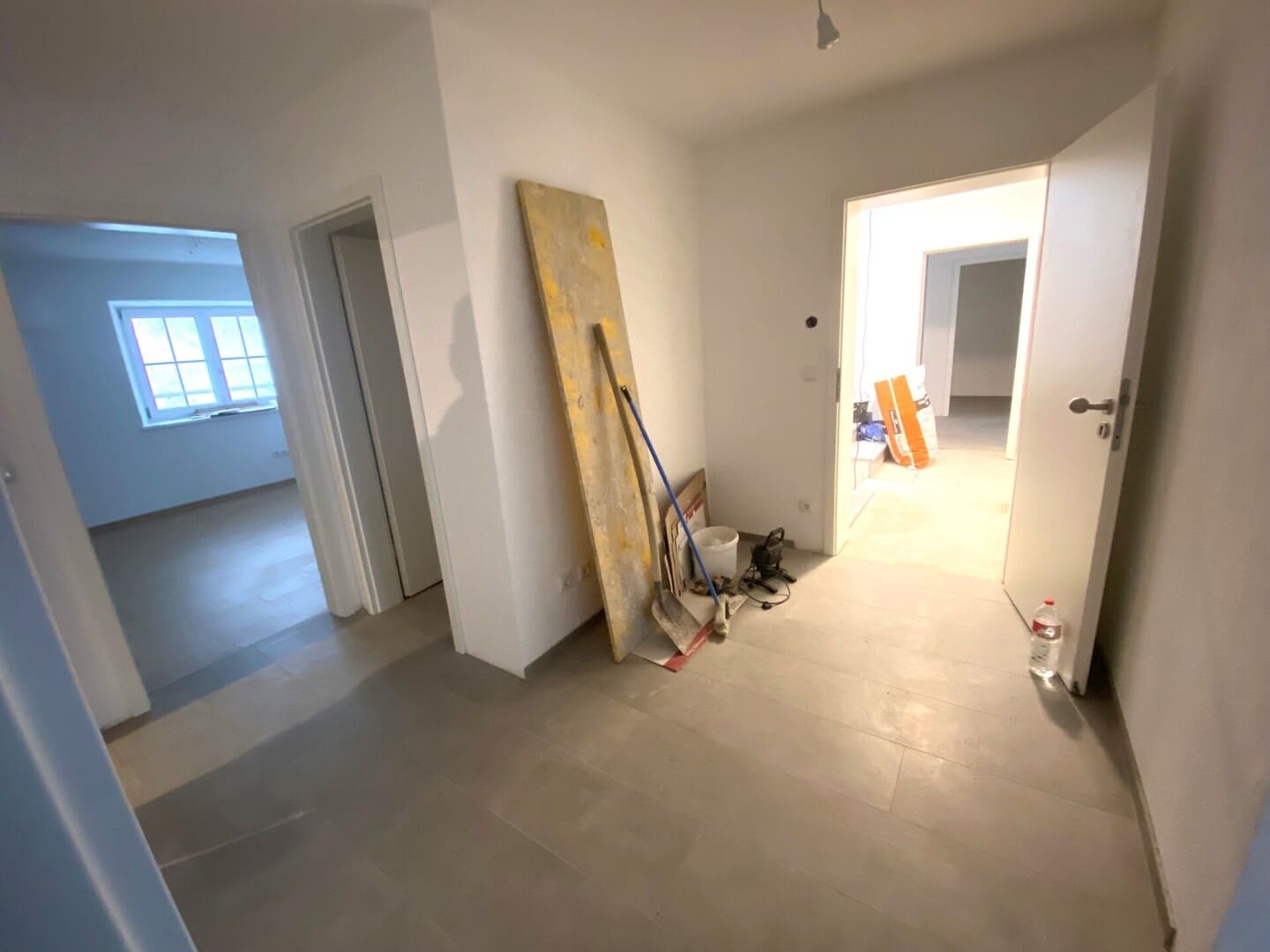 Eingangsbereich der Wohnung mit Fliesenboden und hellem Licht – Neubauwohnung mit eigenem Hauseingang