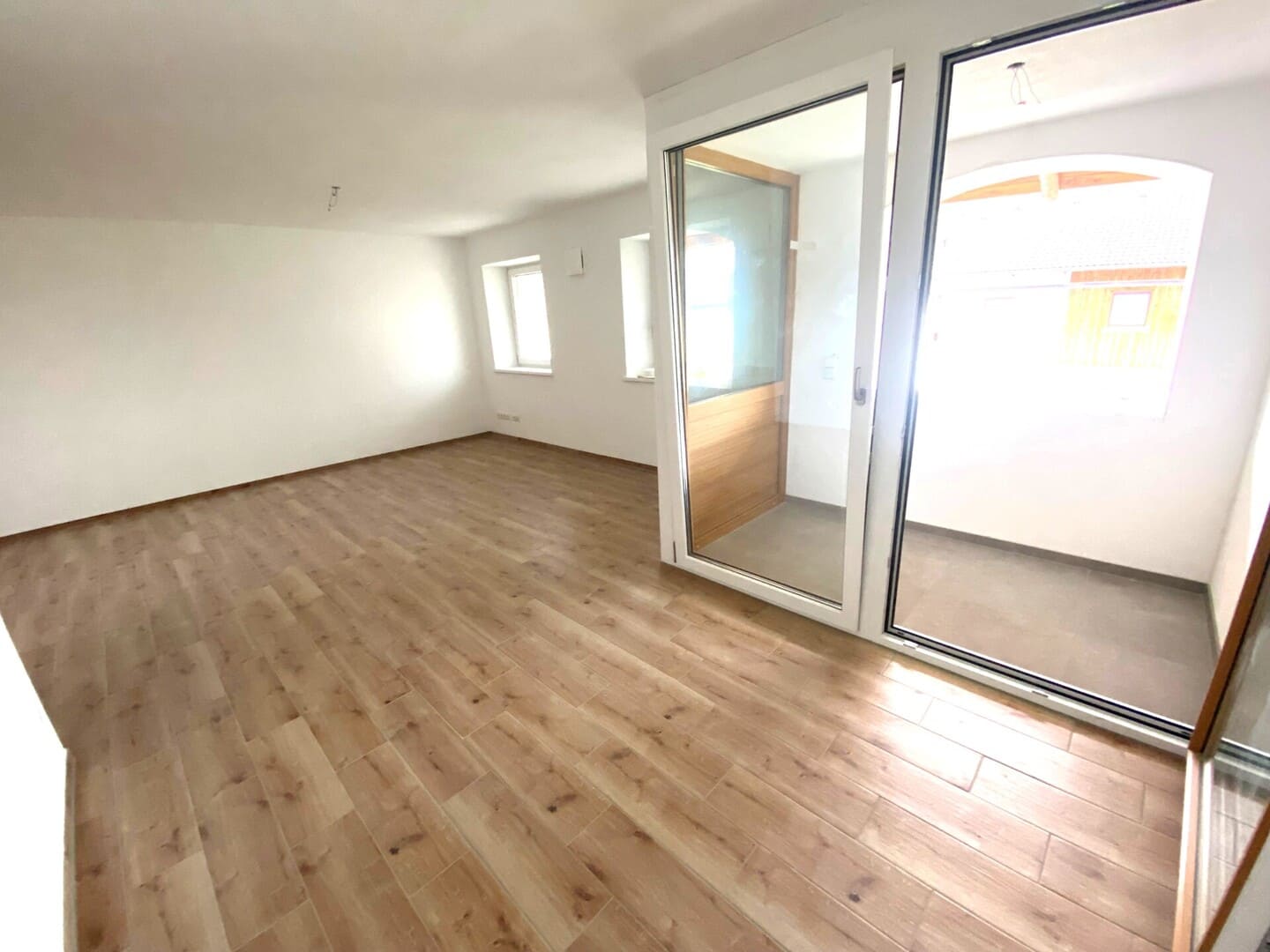 Wohn- und Essbereich mit Fensterfront und integrierter Küche – hochwertige Neubauwohnung mit Loggia